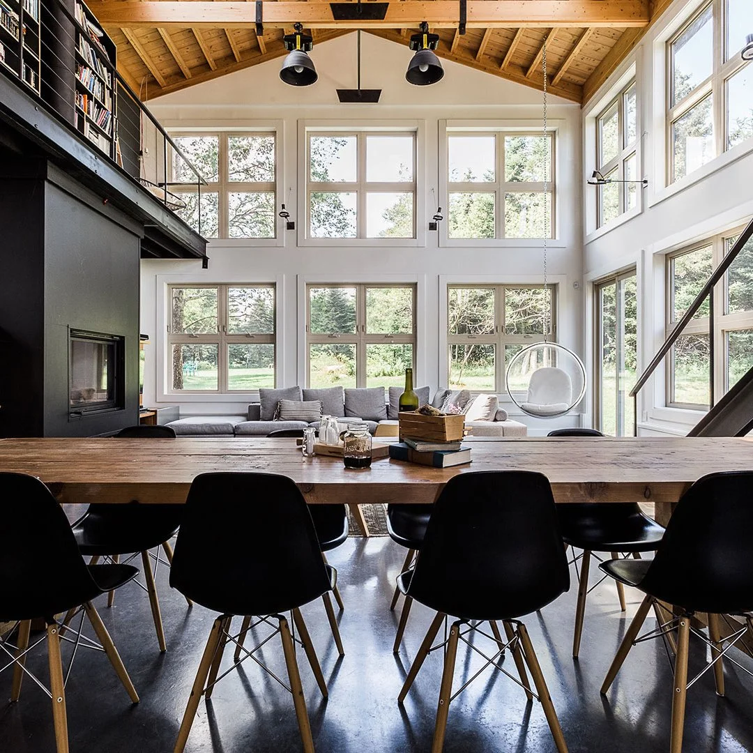 black-eiffel-chairs-in-front-of-wooden-table-in-large-living-dining-space-close-up.jpg