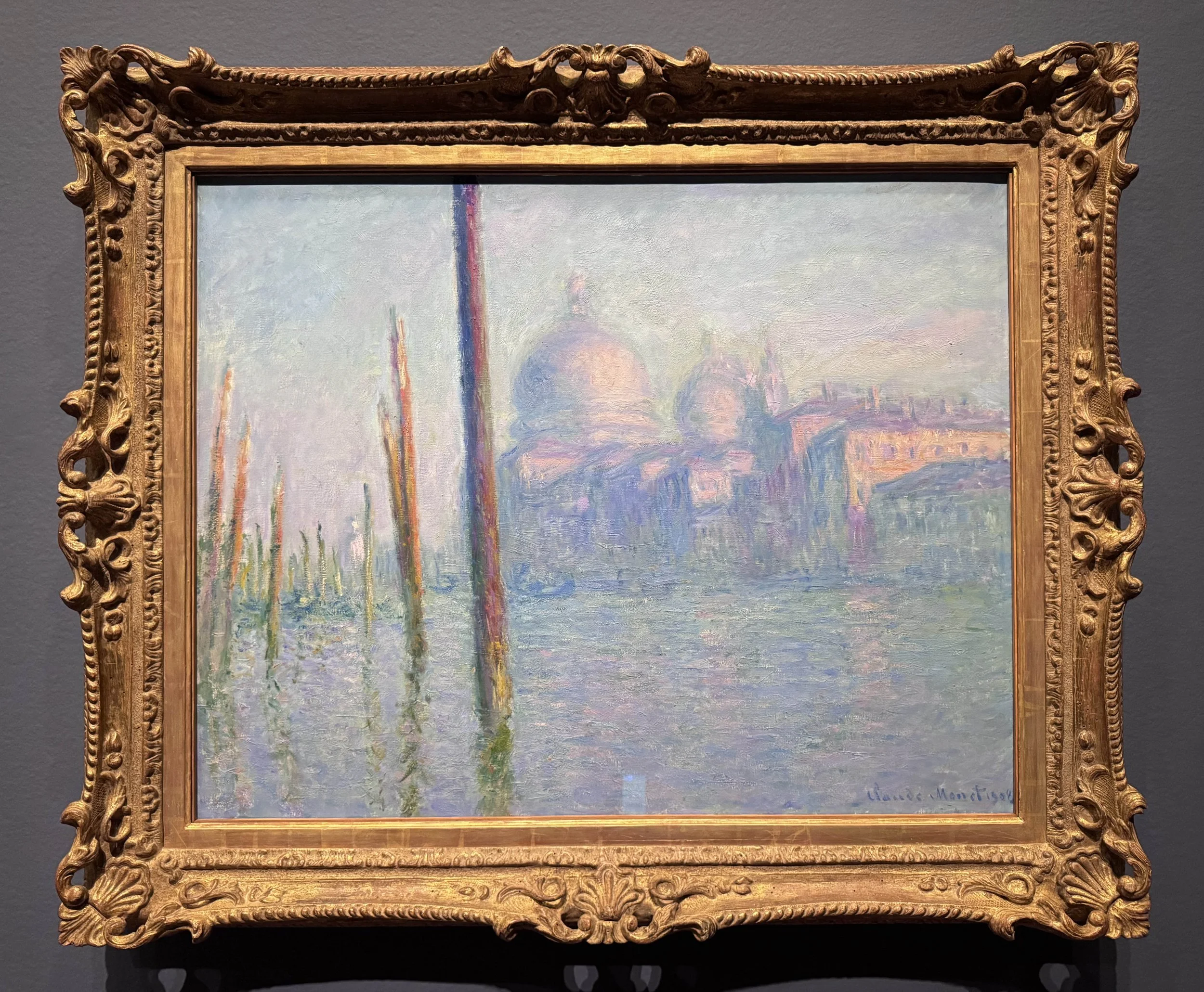 Claude Monet painting of the grand canal Venice, in soft pastel shades, with muted greens and soft violet predominating. The Santa Maria della Salute church is across the canal.