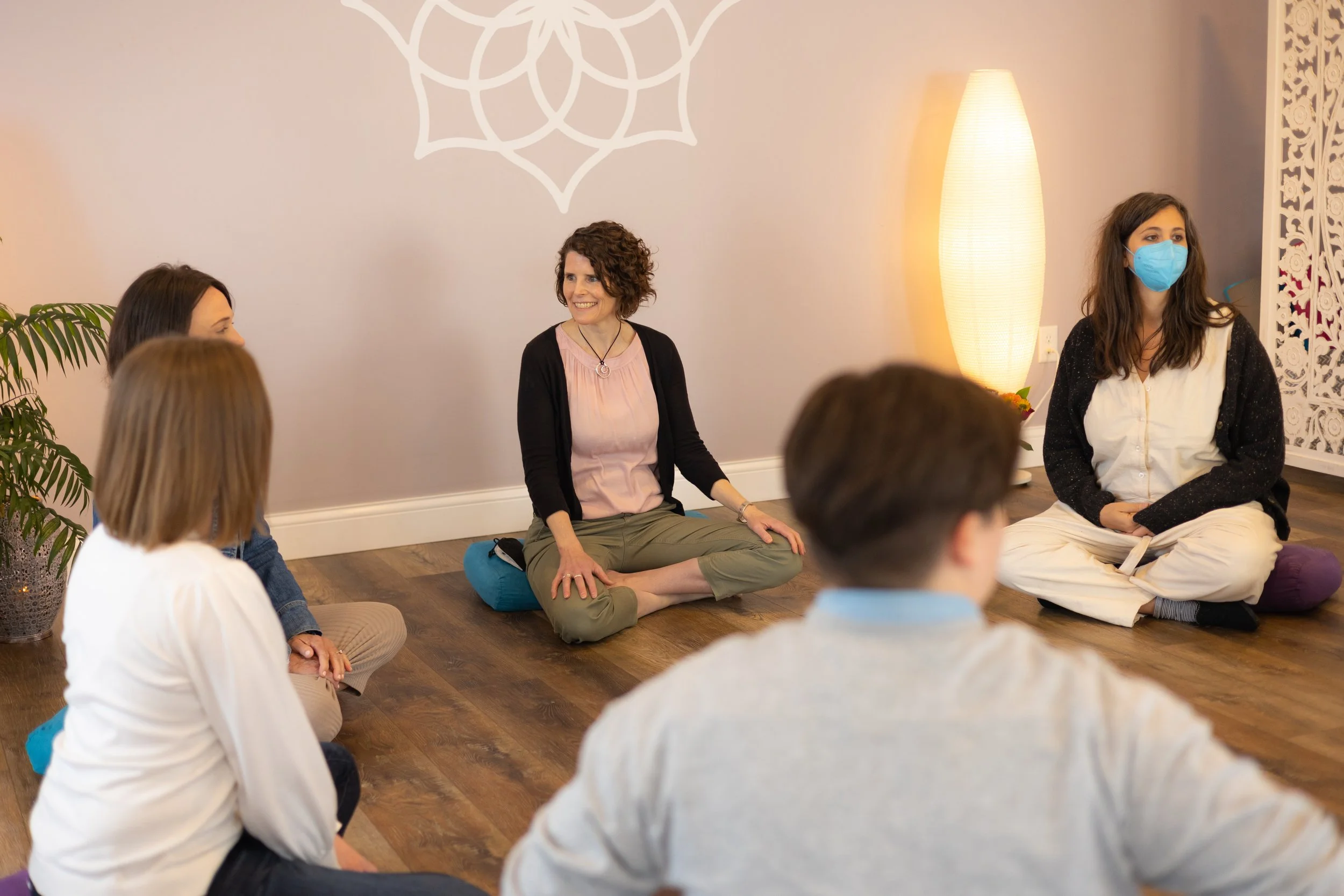 Empowered Spaces members sitting cross-legged in a circle in the Empowered Spaces Studio