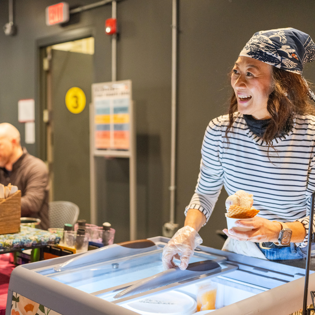 Woman smiling serving ice cream.