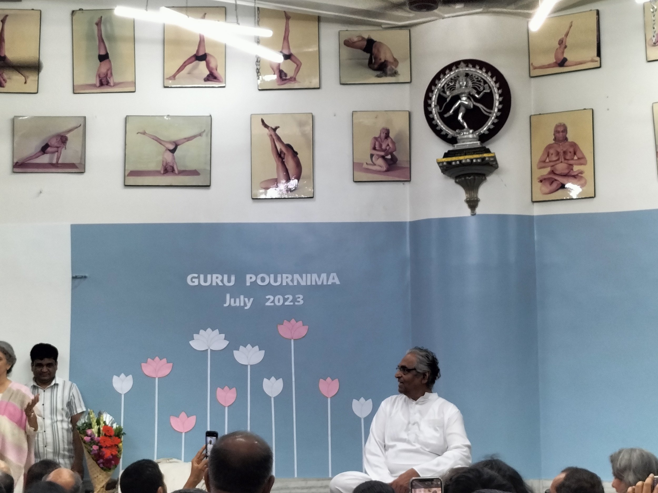 Yoga hall decorated with posters of poses and a statue of Shiva, during Guru Pournima event in July 2023.