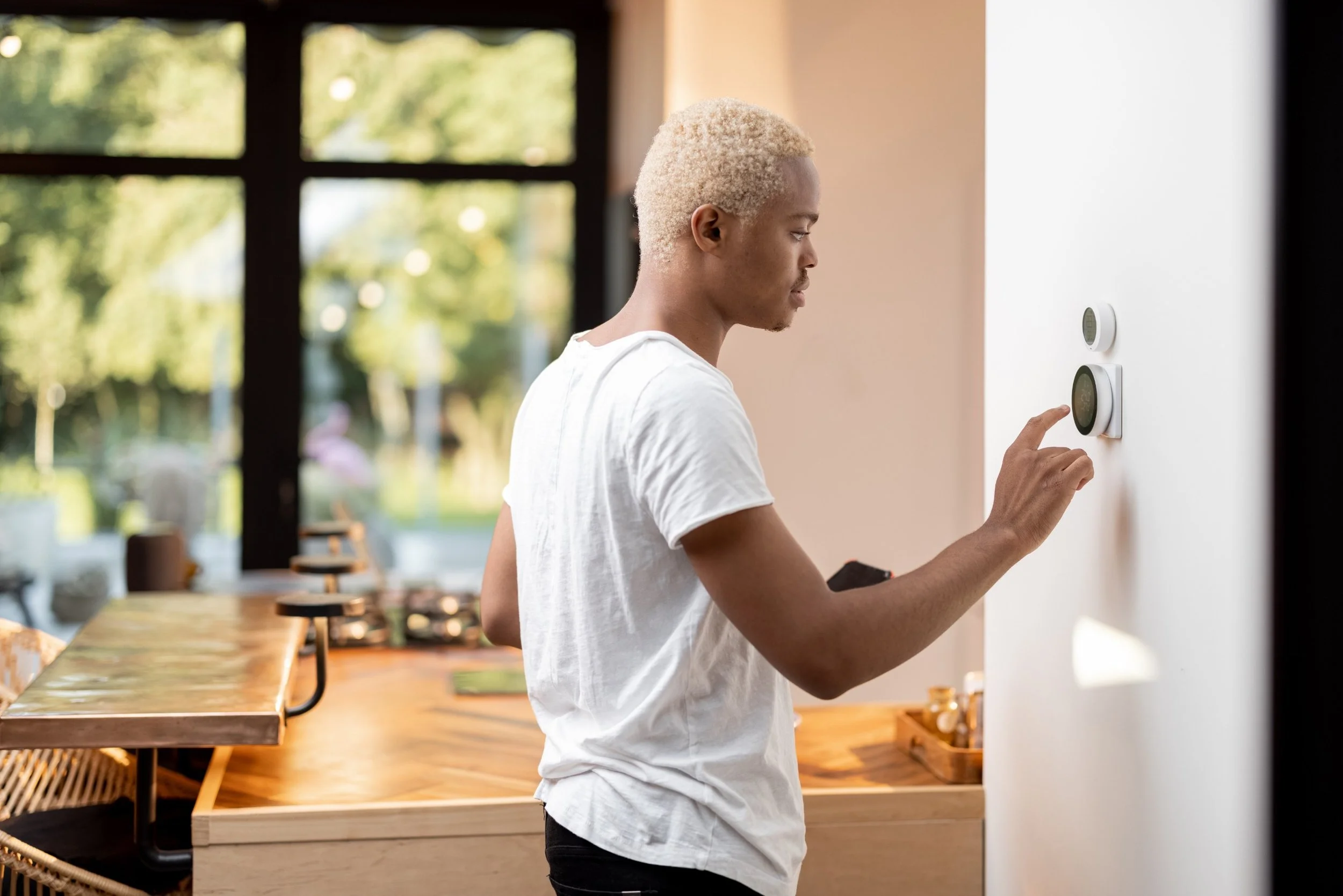Person adjusting a smart thermostat for precise temperature control and improved home comfort.
