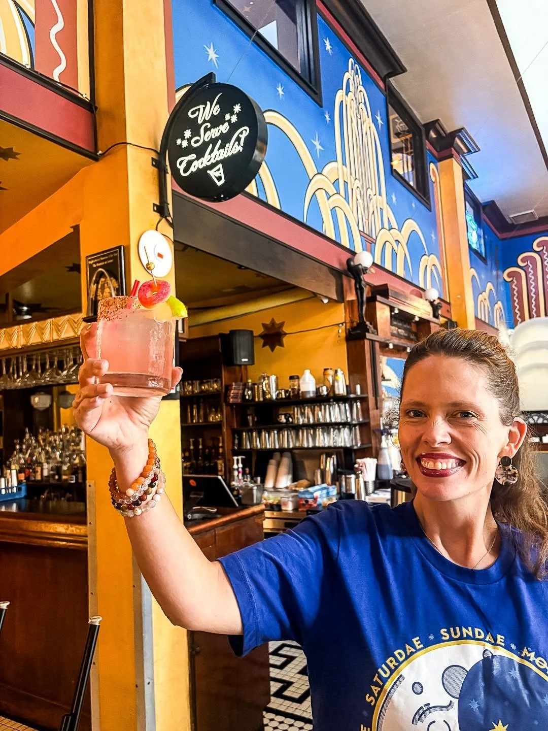 Fountain owner Danni Eickenhorsts holds a cocktail aloft in the dining room of The Fountain on Locust known for the best cocktail in st louis.