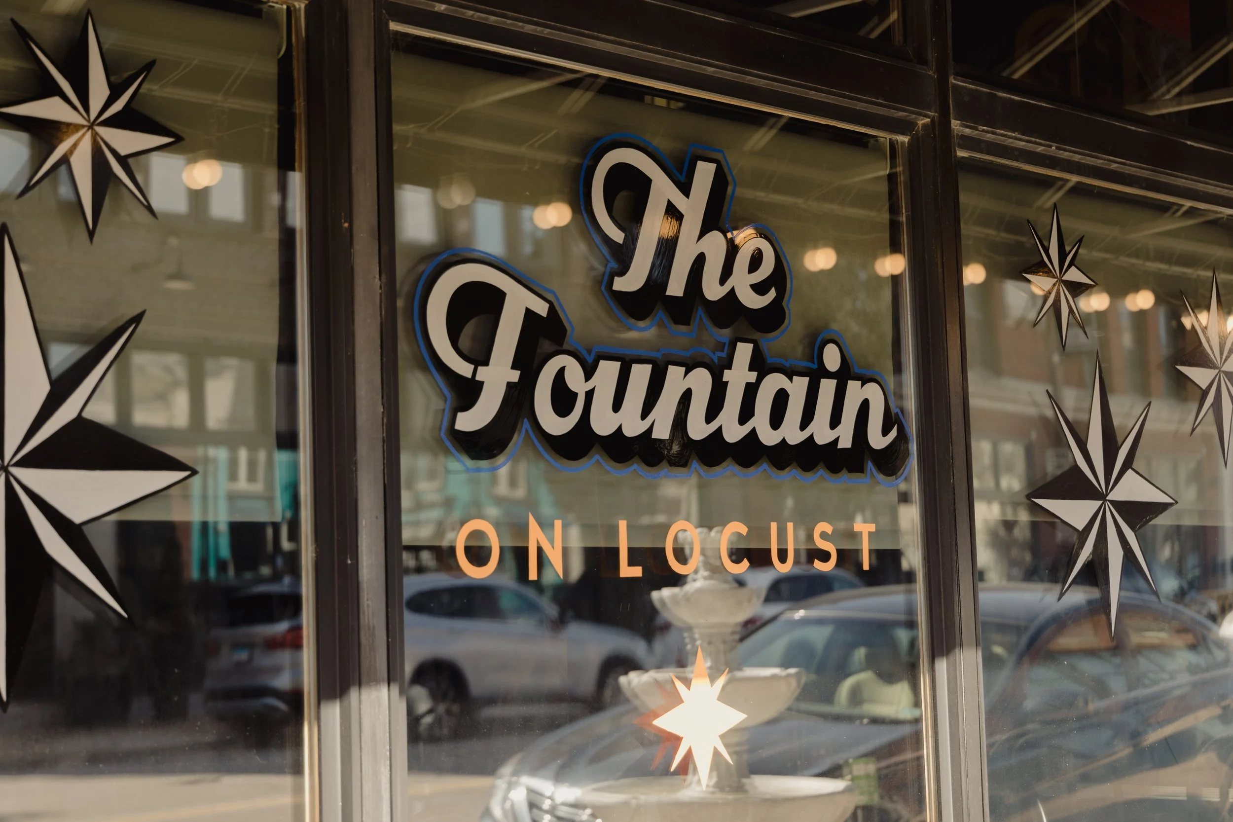Front painted windows at Private event space rental at The Fountain on Locust featuring hand-painted Art Deco murals and vintage booth seating in Midtown St. Louis.