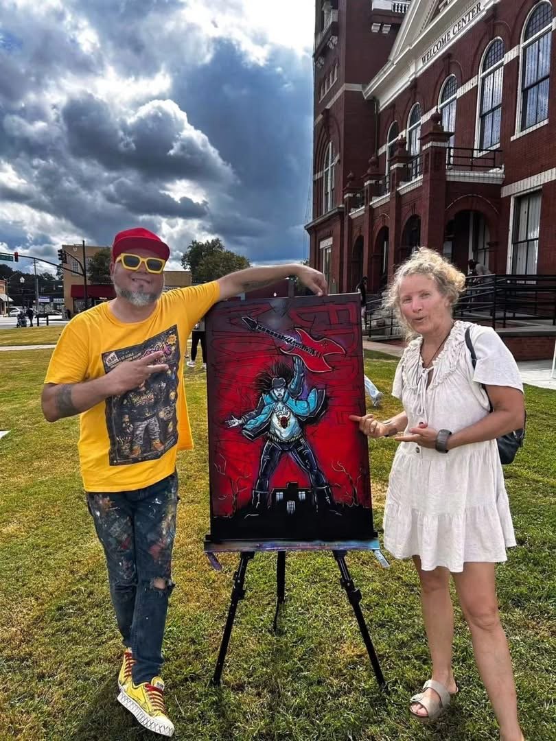 Artist Wil Rivera and Ellen King paint Stranger Things themed art on the square