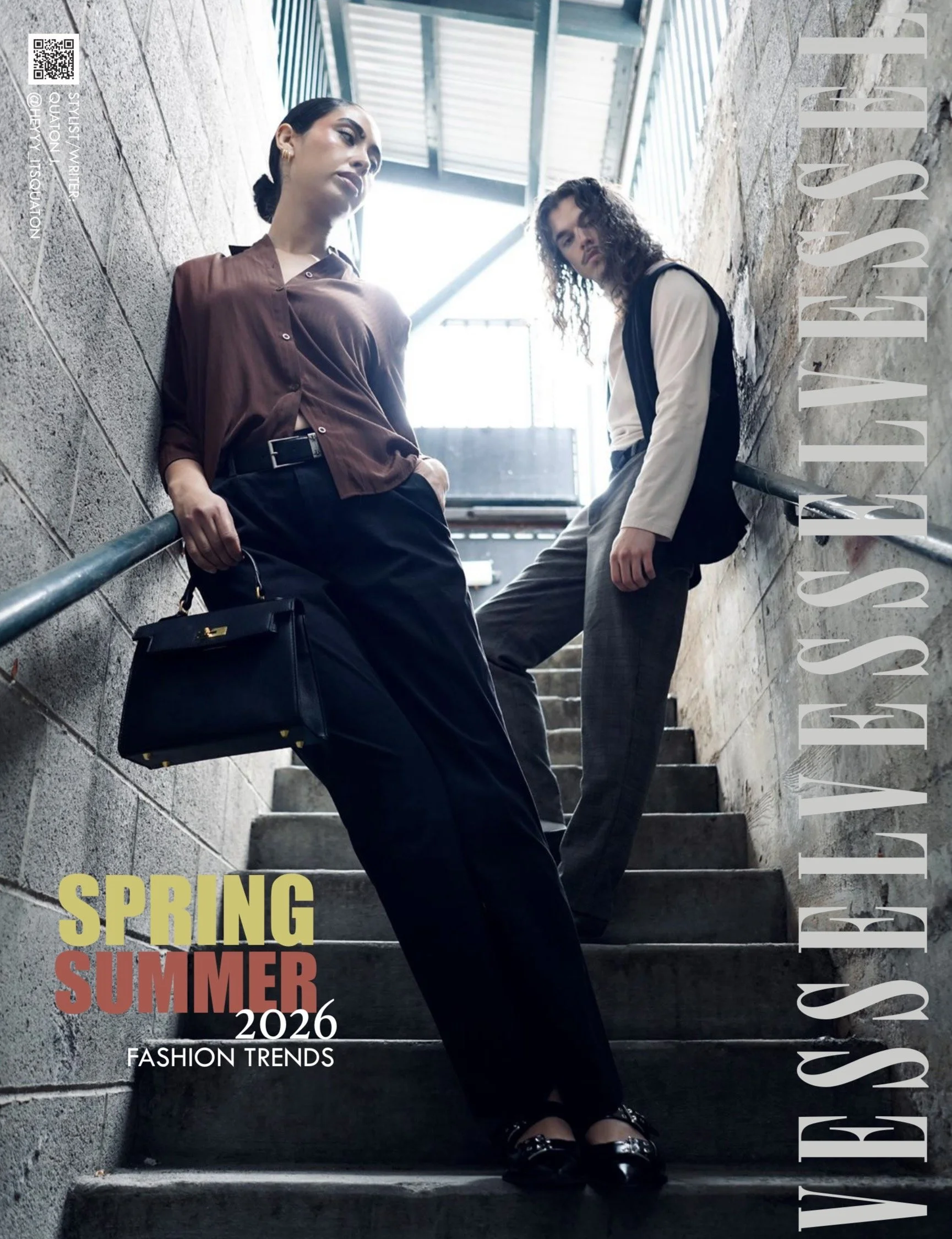 Two women sitting on outdoor stairs with a brick wall on the right and a railing on the left. The woman on the left has dark hair tied back, wearing a brown long-sleeve blouse and black pants, holding a black handbag. The woman on the right has curly hair, wearing a light-colored blazer and plaid pants. The photo has overlay text that reads "Spring" in yellow, "Summer" in red, and "2026" in white, along with additional text about fashion trends.