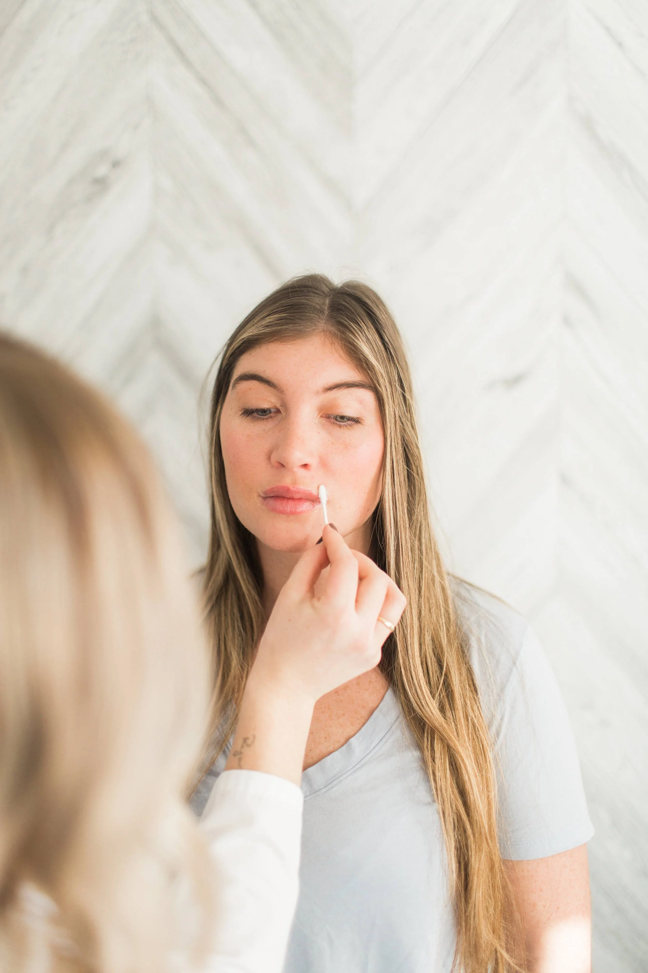 client getting lips numb for lip filler treatment