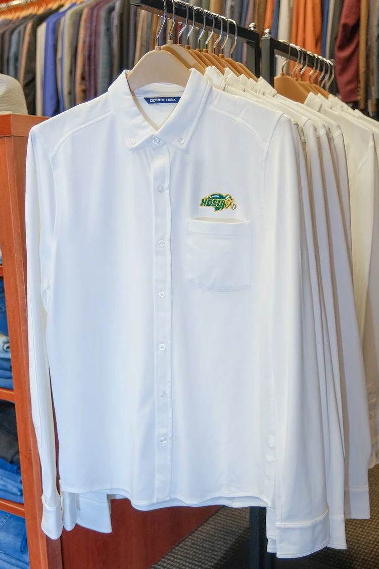 White dress shirts with an embroidered Bison logo on a store rack