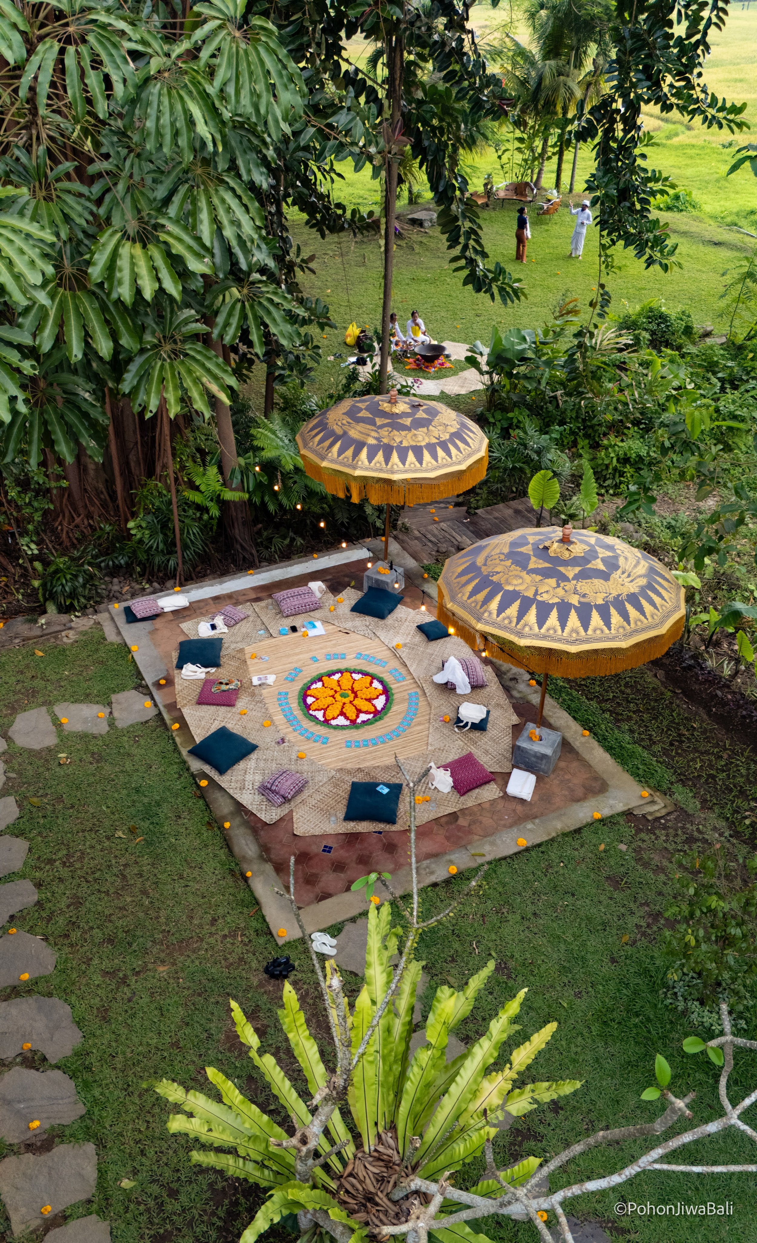 A lush garden scene with a decorated outdoor area for meditation or yoga. High-end retreat center in Pejeng, Ubud, Bali
