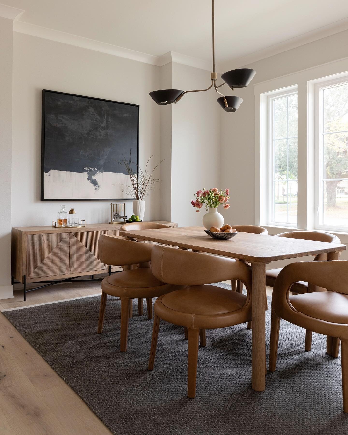 Dine in 🖤 The dining room at our Pensacola Modern New Construction incorporates natural materials for warmth, mixed metals for variety &amp; deep hues for contrast. A balanced space made for gathering. Designed by Corio Design House. 

Photography b