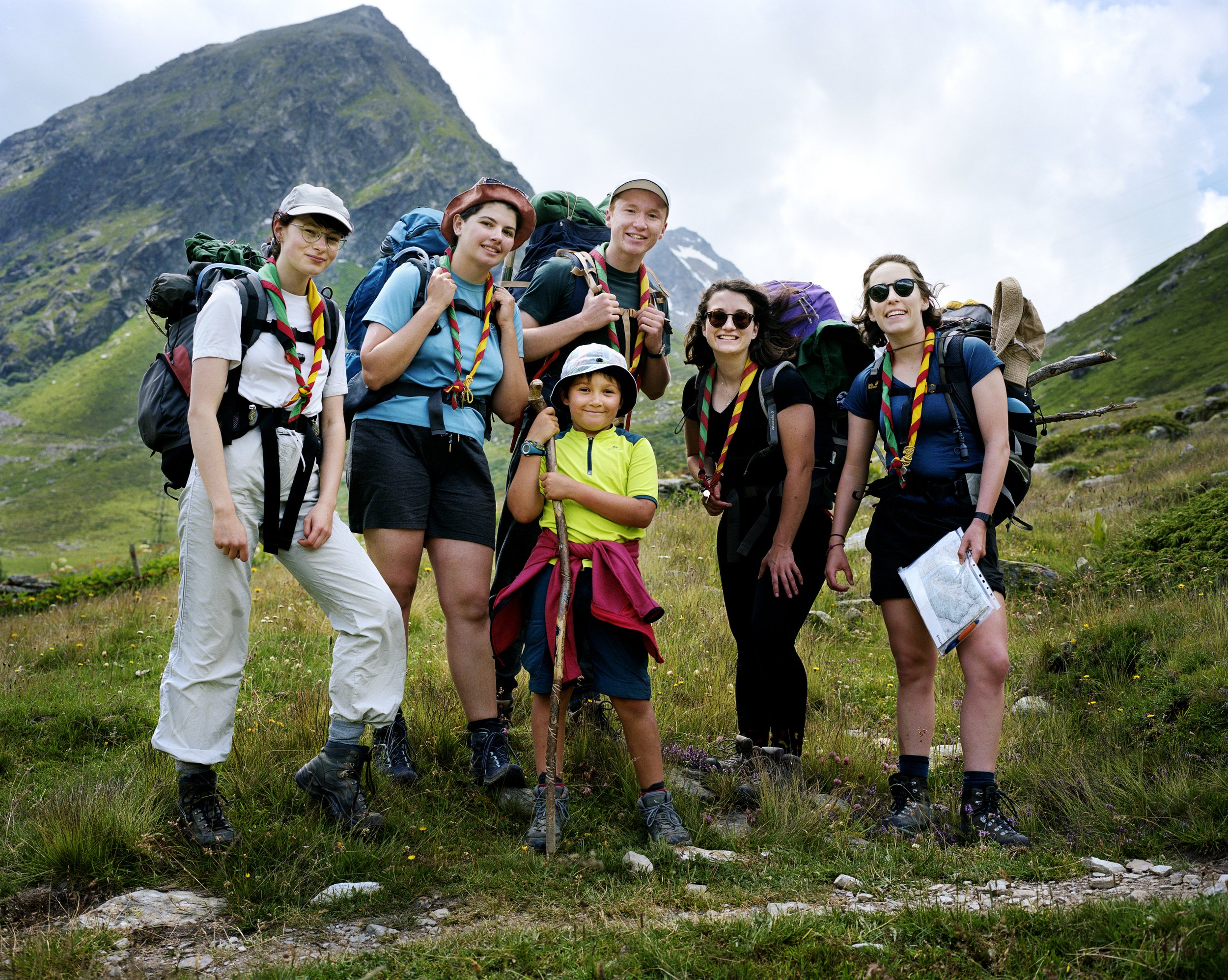 Group of hikers with backpacks in a green mountain setting
