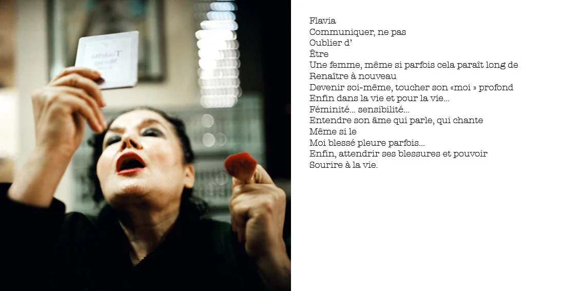 Une femme regarde un miroir tout en se maquillant, tenant un rouge à lèvres dans la main gauche.