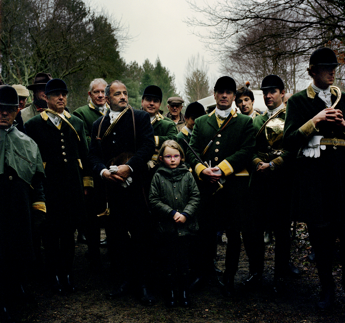 Groupe de personnes habillées en vêtements historiques, avec certains portant des uniformes militaires, sous un arbre, lors d'une cérémonie ou d'un événement commémoratif.
