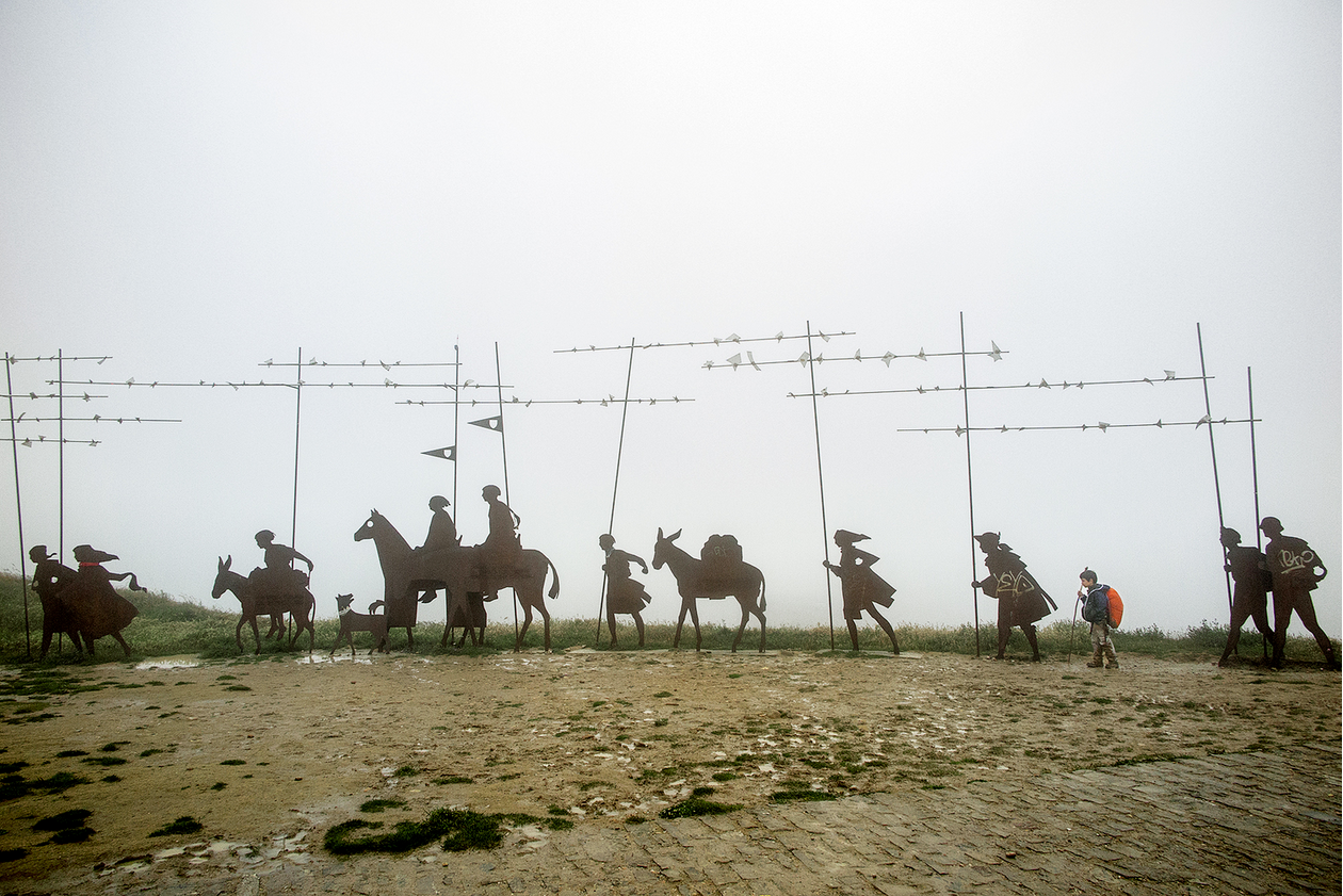 Metal silhouettes of travelers with camels, dust and fog