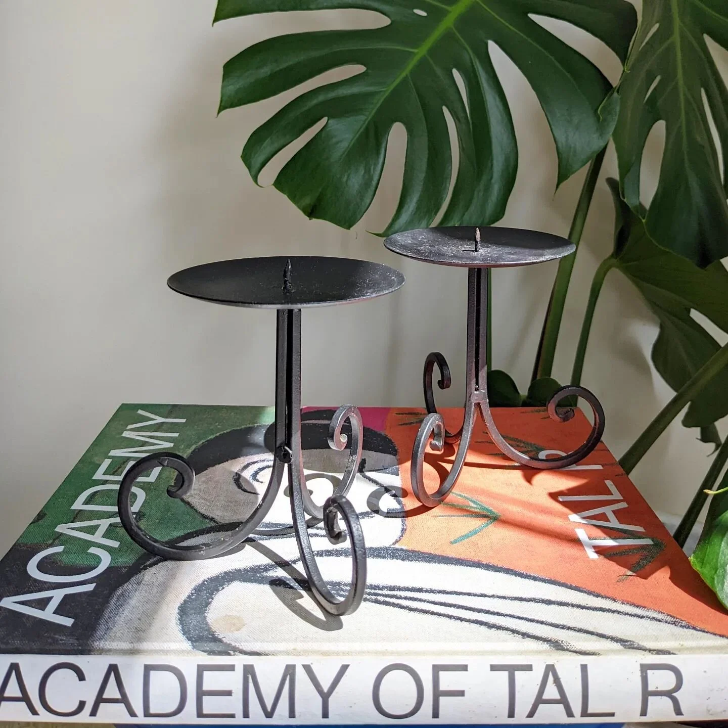 Curls get the candles. 

Pair of candle stick holders. Base is a tripod of curly, scrolled black metal. Postage available. 

Say hey for $30