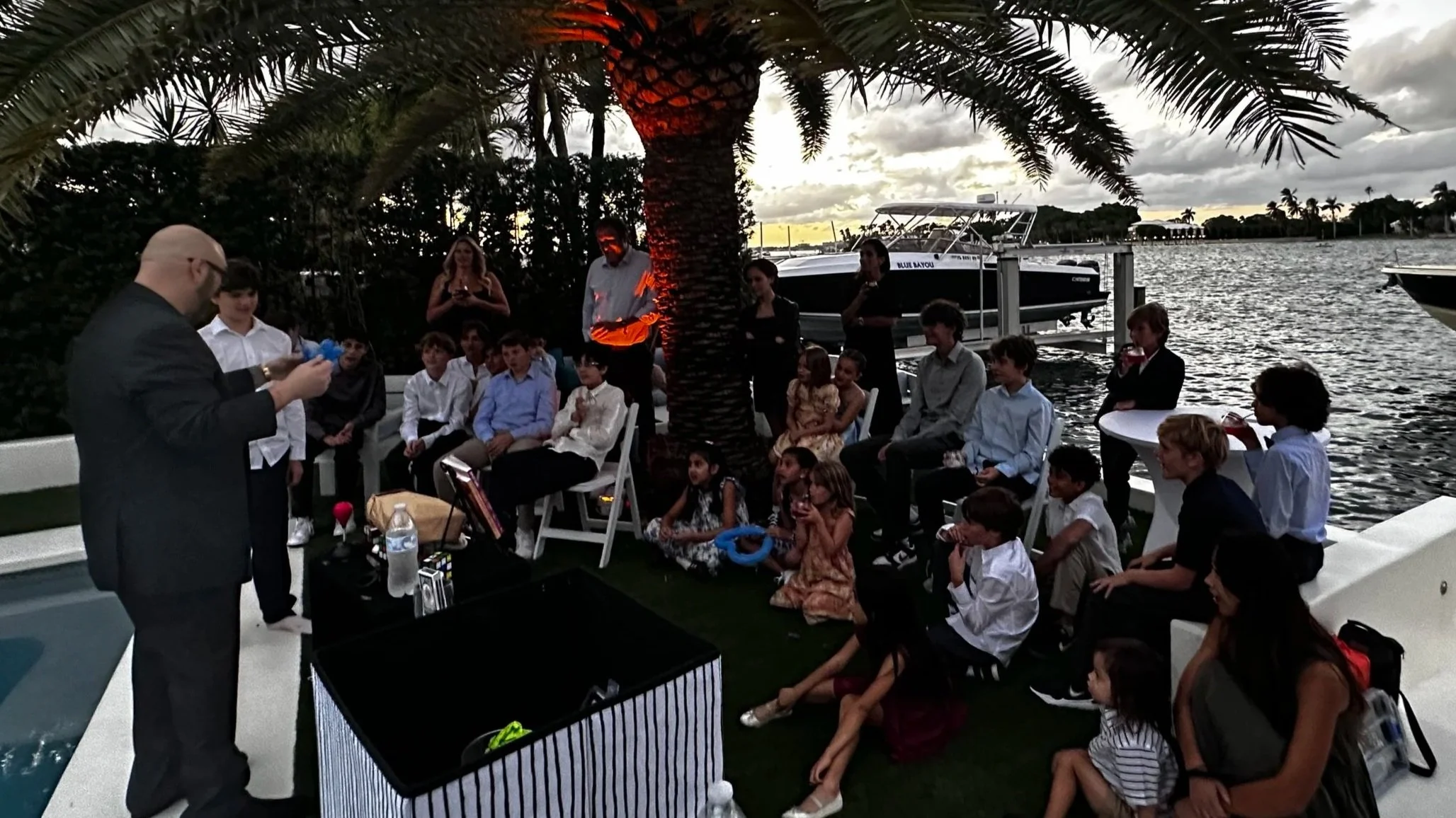 Big Joey Magic Showy is seen performing an outdoor magic show event on the beach.