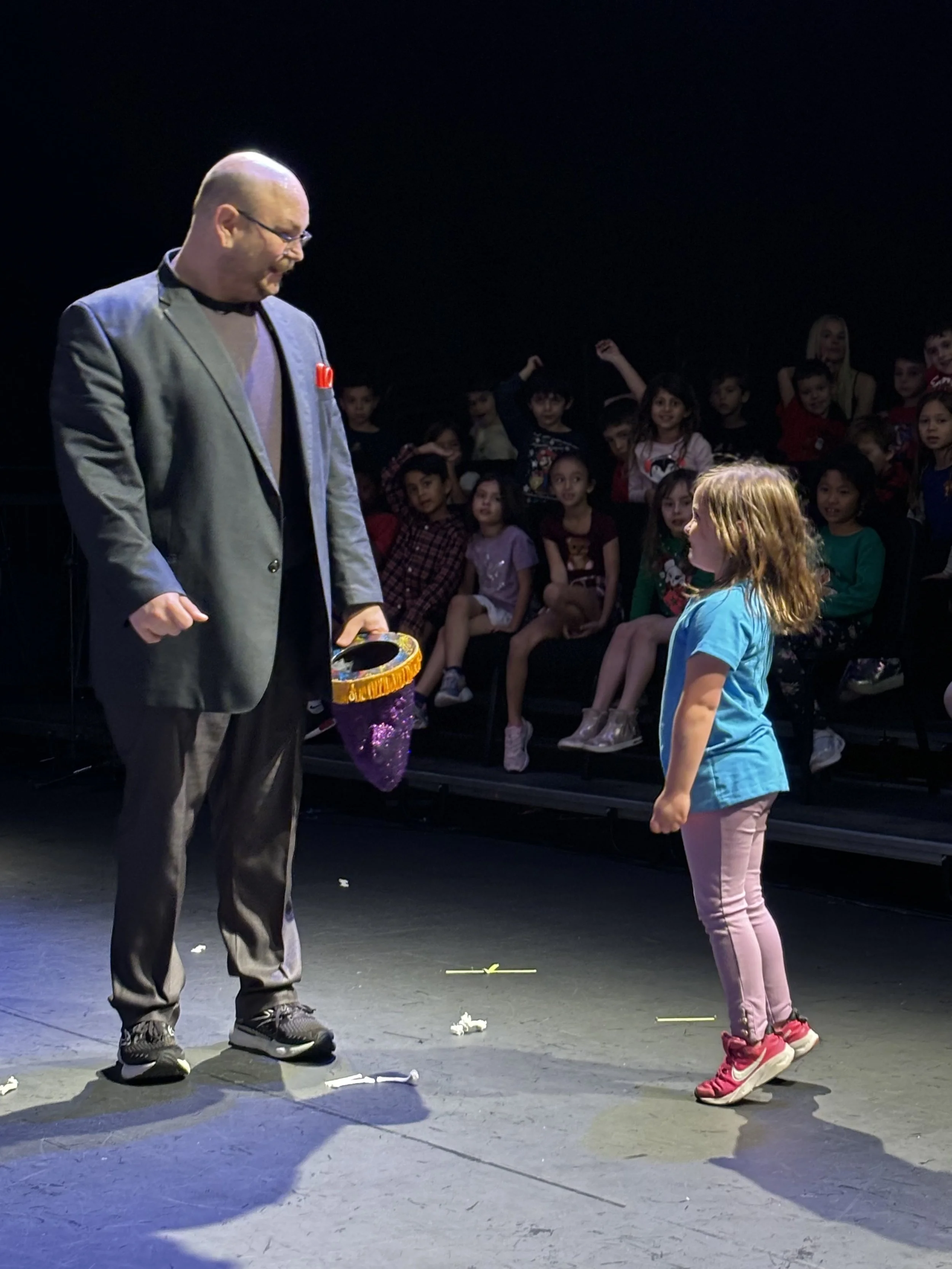 Birthday child helping Big Joey Magic Showy perform a magic trick during a kids birthday party magic show.