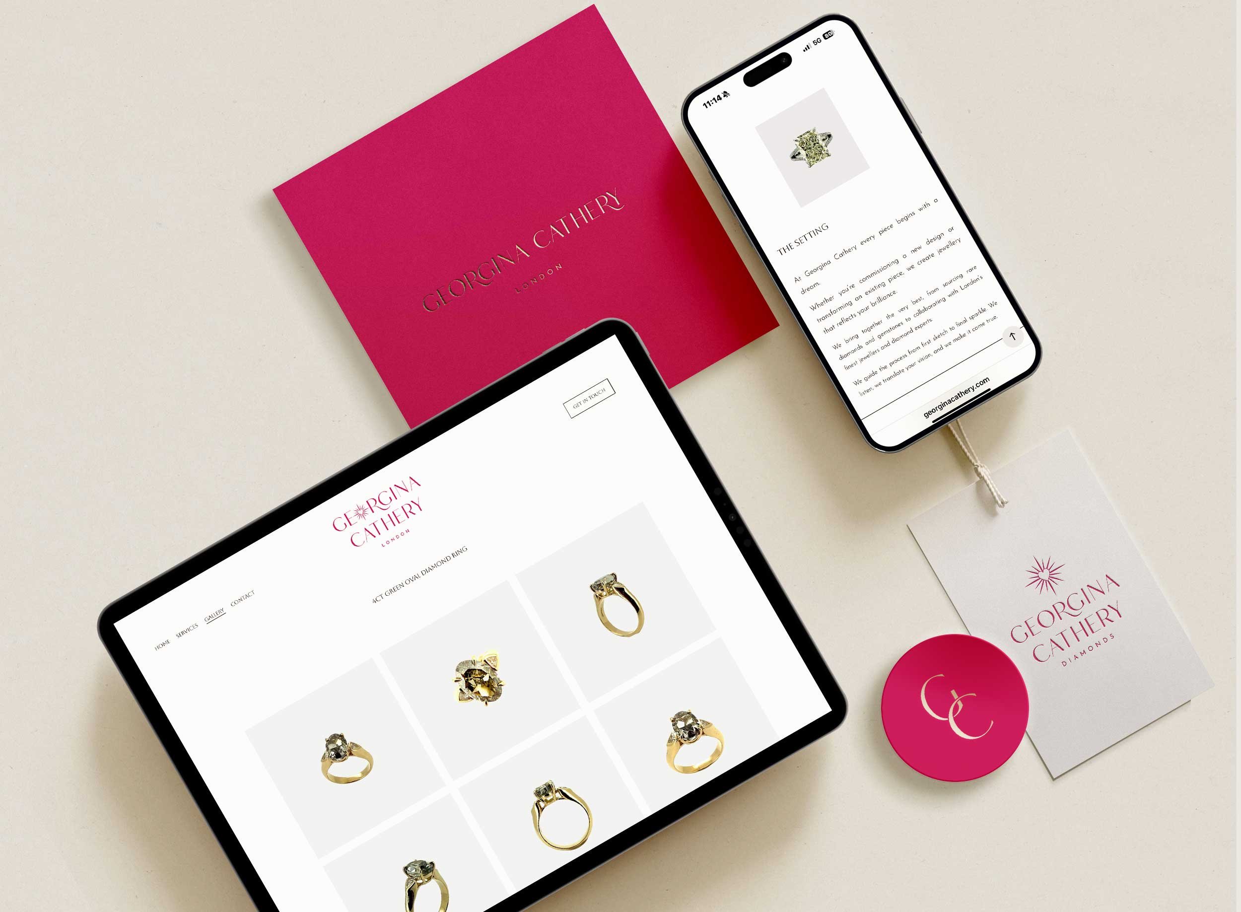 Image of a website displaying various diamond rings, two smartphones showing a page with jewelry details, a pink 'Giorgina Cathery' jewelry box, and jewelry branding materials on a white surface.