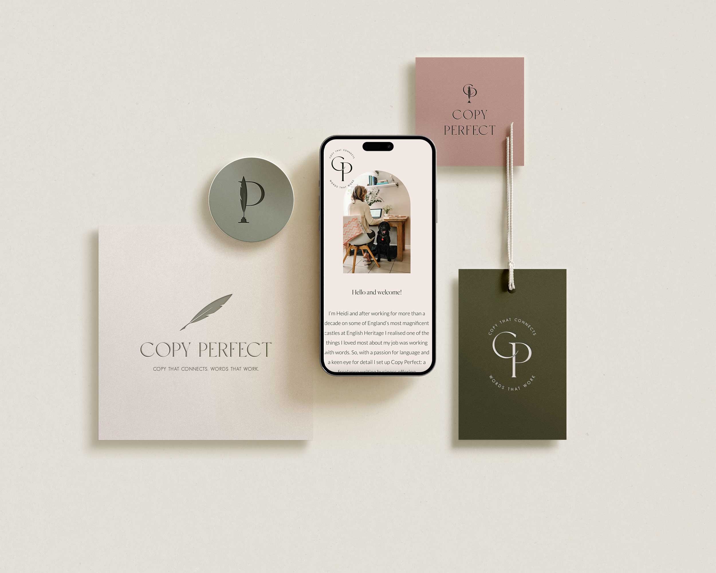 An overhead view of a light-colored workspace with branded materials for Copy Perfect, including brochures, business cards, and a smartphone displaying a website, on a white surface.