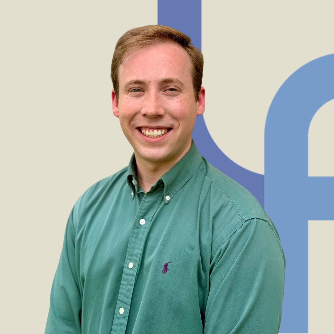 Profile picture depicting John Kinlaw, resident in counseling, smiling. He wears a green shirt and stands in front of the LaunchPad Logo.
