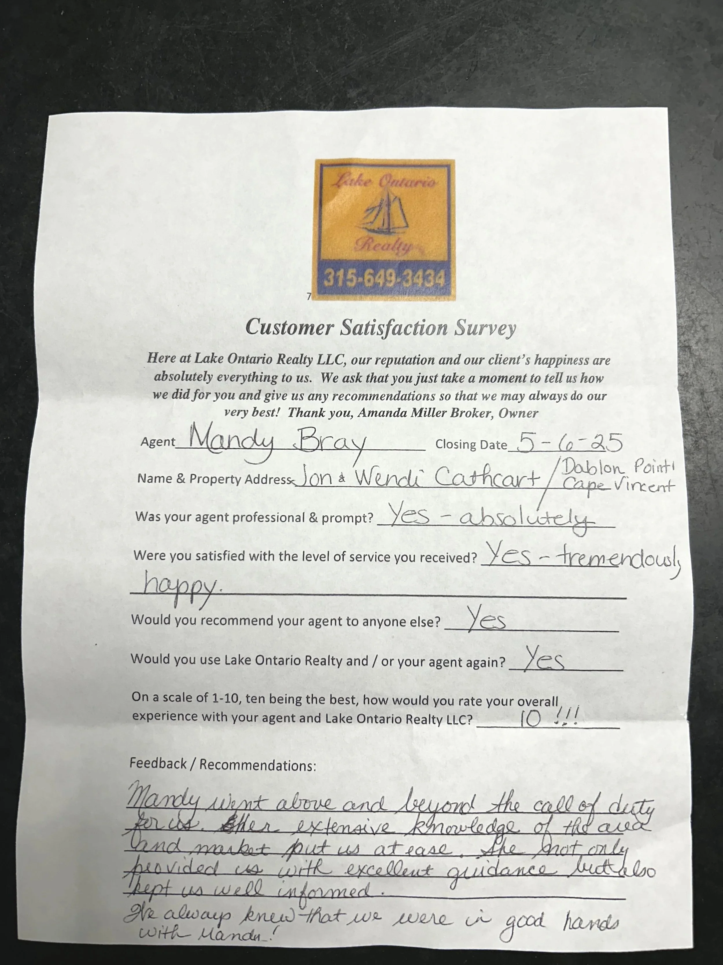 Customer satisfaction survey form from Lake Ontario Realty LLC with handwritten responses, including agent Mandy Bray and property address Jon & Wendi Cathcart in Cape Vincent, NY. The survey includes ratings, comments, and contact information.