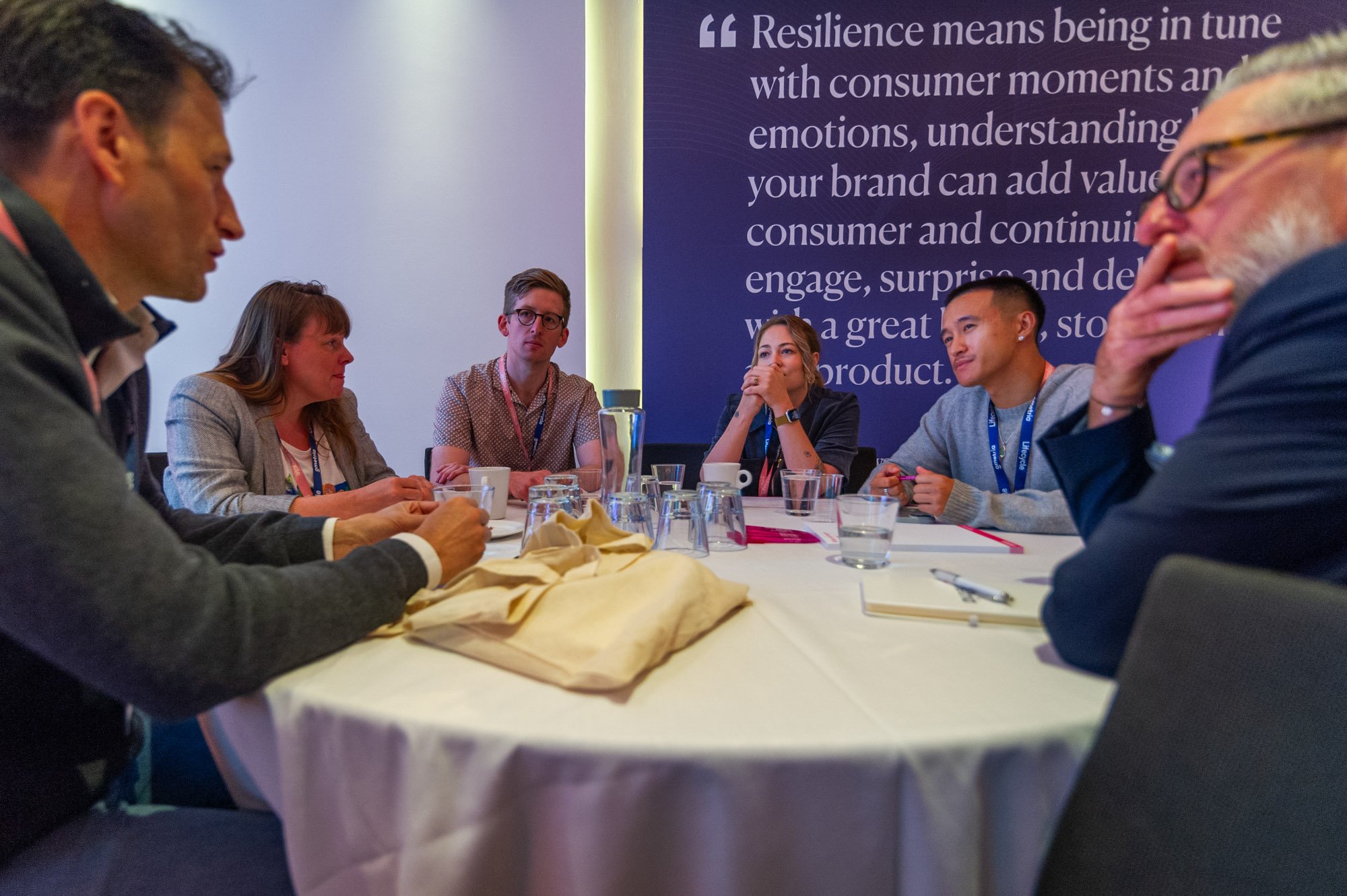  A diverse group of people discussing while sitting around a table.   