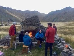 Meg Hut, evening around the hearth from original hut