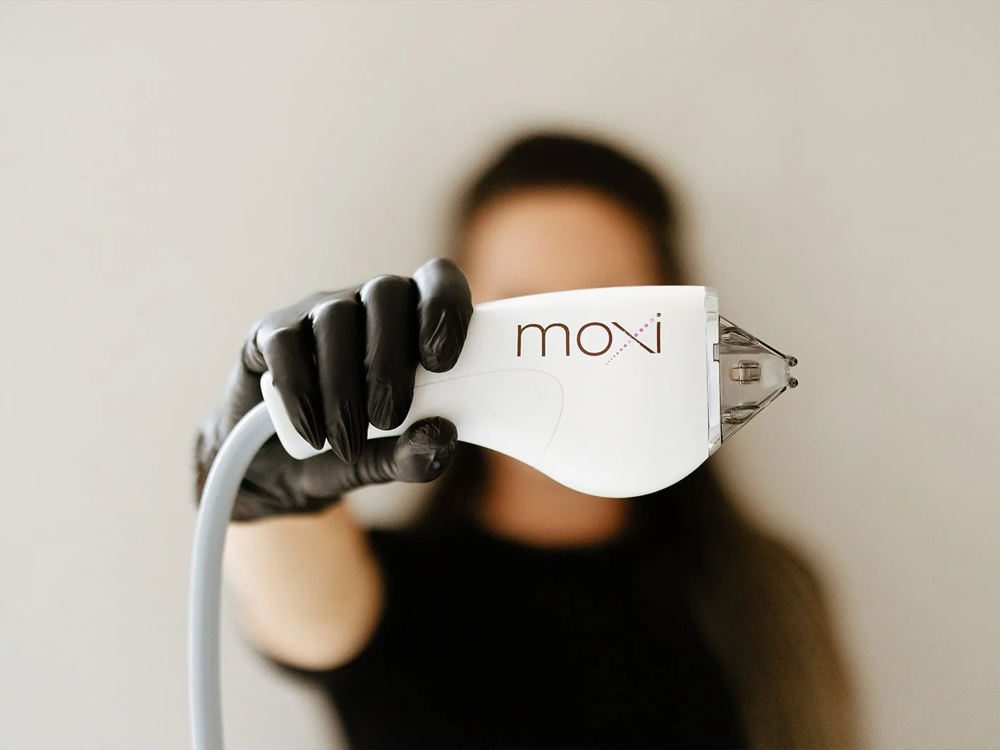 rovider holding the Sciton MOXI fractional laser handpiece at Reviv Lounge in Oconomowoc, Wisconsin.