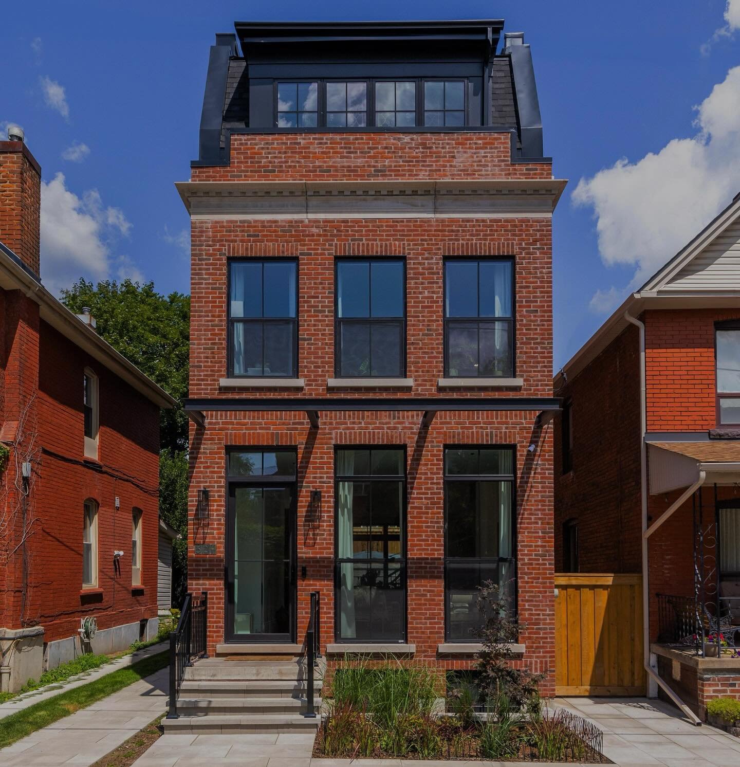 Blending timeless charm with contemporary design, this transitional city home features classic elements such as box moulded red brick and limestone banding, while incorporating modern touches through the metal cantilevered porch and sleek fibreglass 