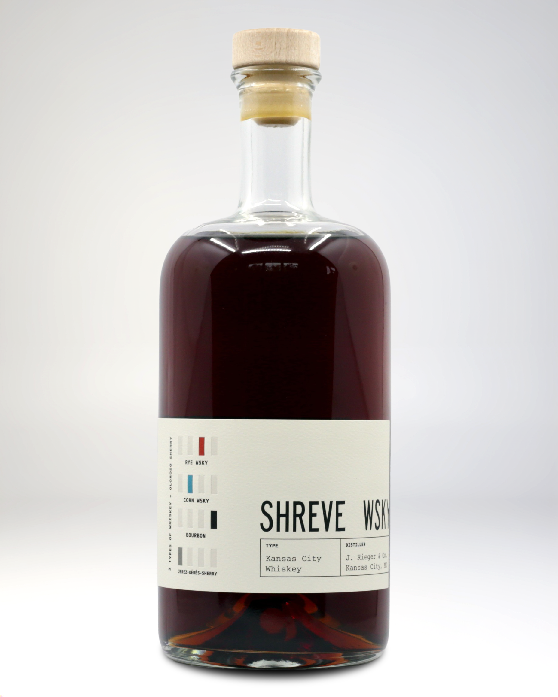 A bottle of whiskey with a label indicating it is a shreve whiskey from Kansas City, produced by J. Rieger & Co. The label shows a barcode, whiskey types, and distiller information.