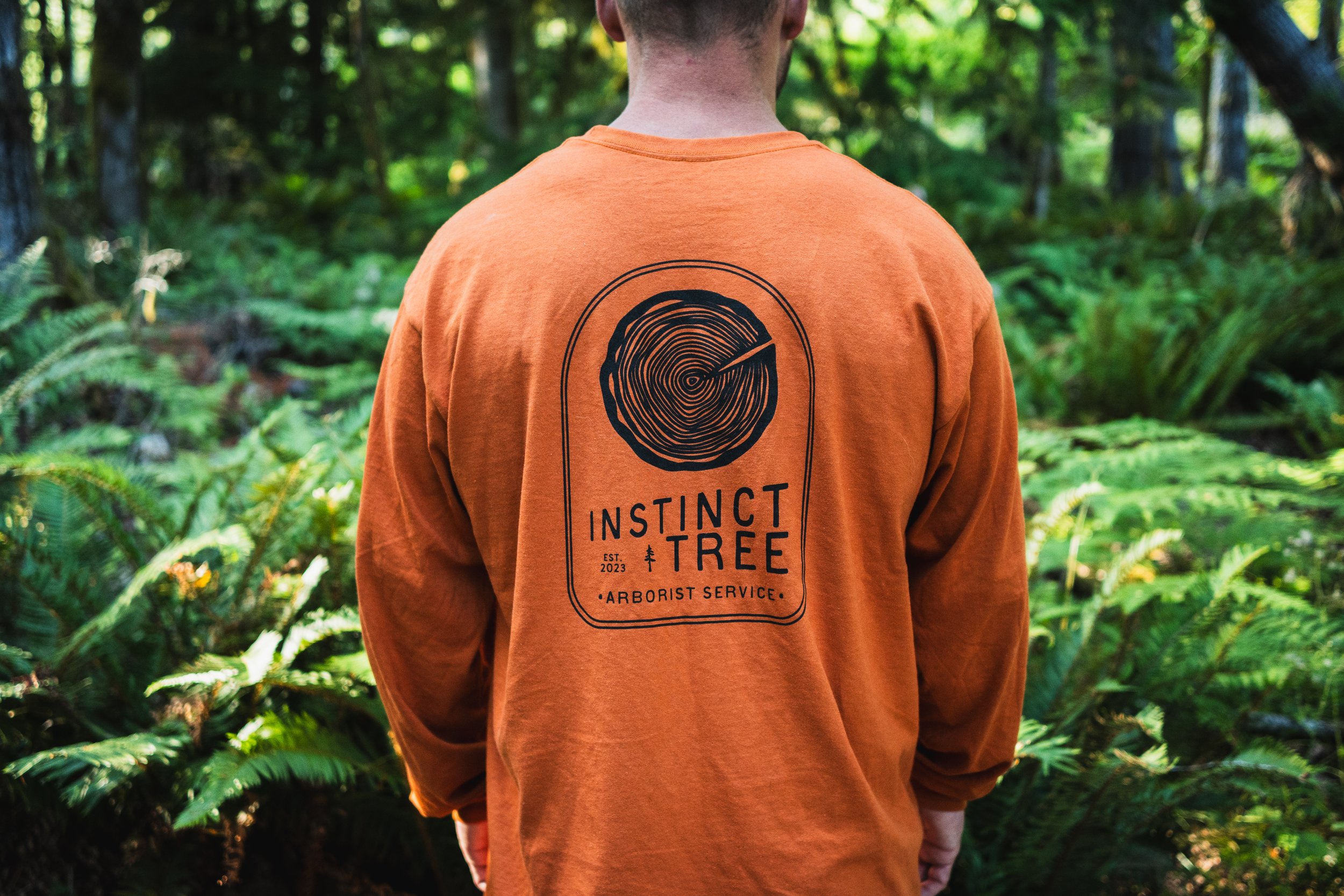 Hand-drawn logo printed on shirt for Instinct Tree Arborist Service