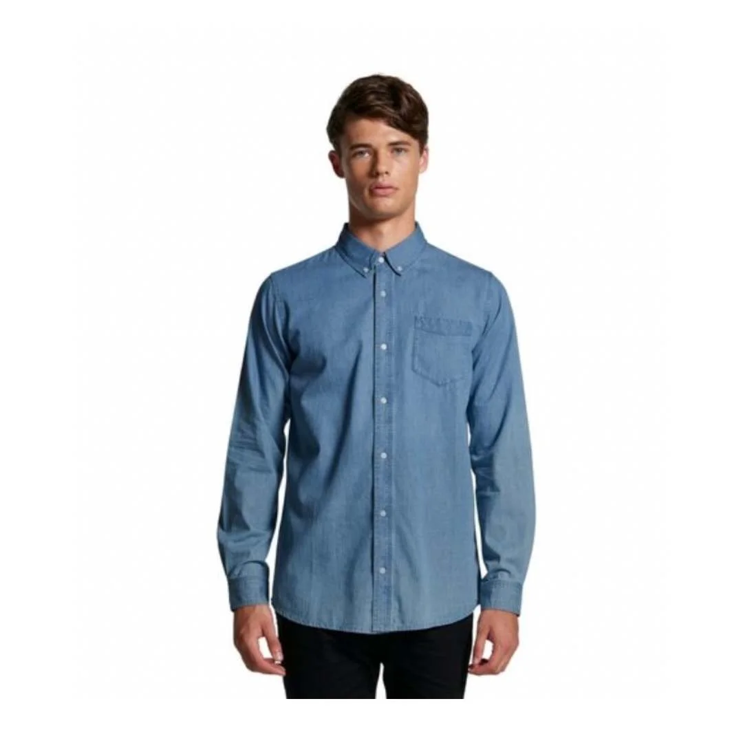 Young man wearing a blue button-up denim shirt against a white background.