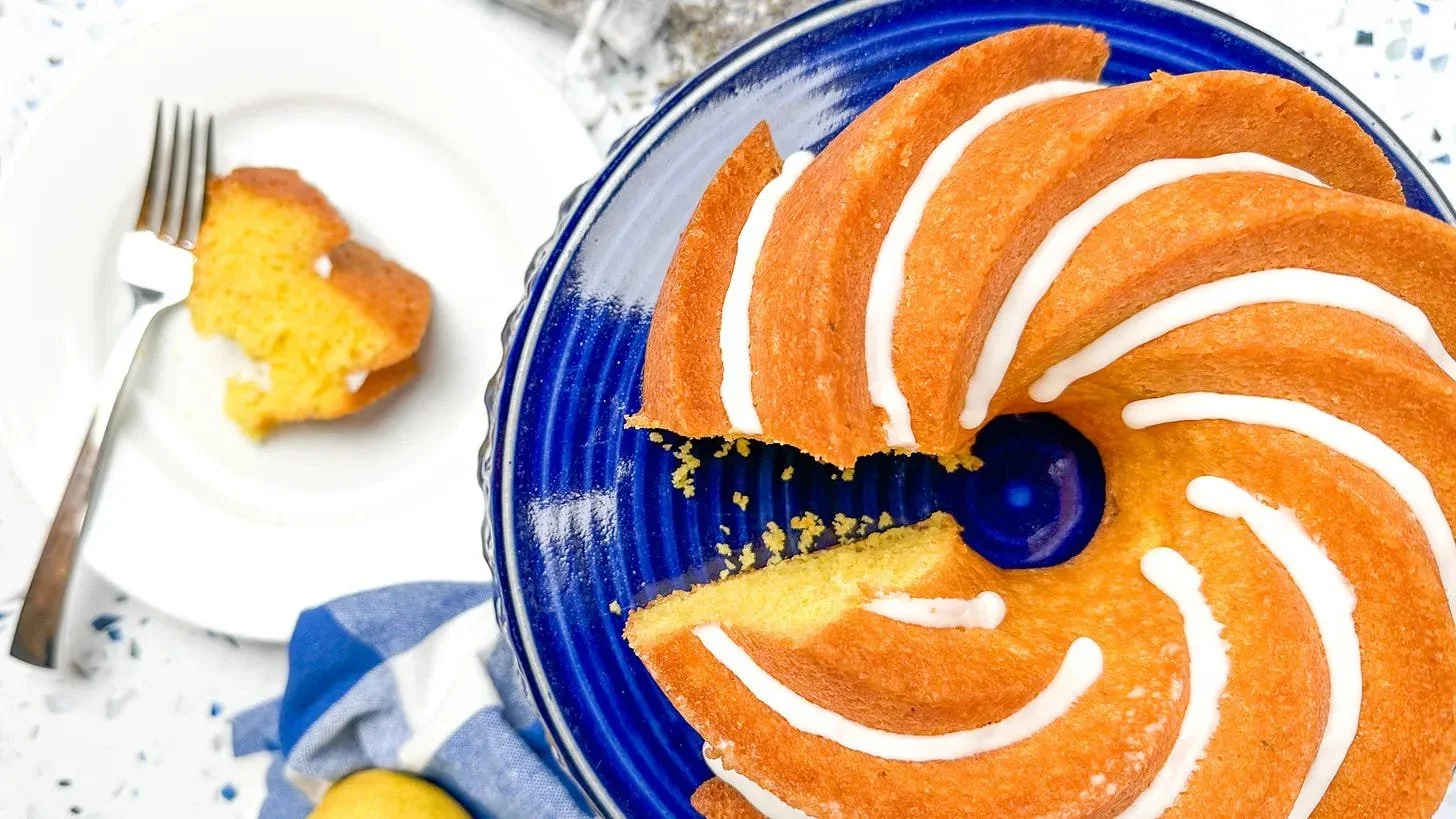 Photo of a yellow Bundt cake on a blue cake stand.