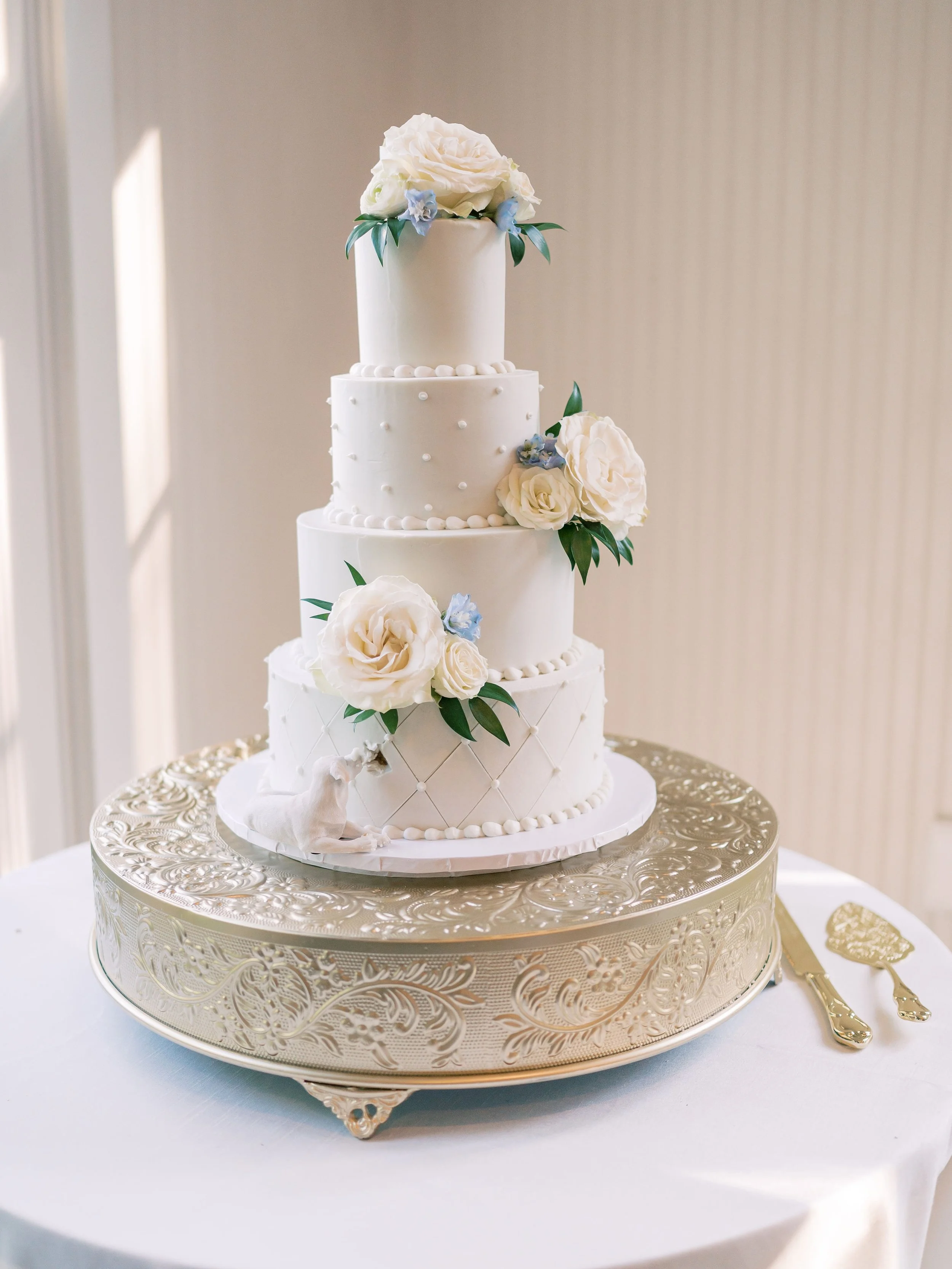 Elegant four-tier wedding cake with live floral design.
