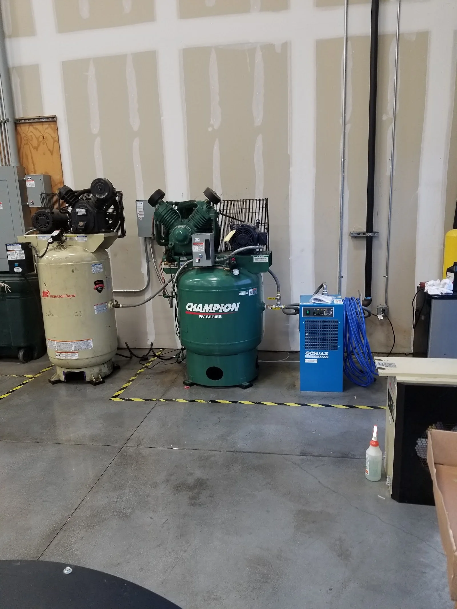 An Ingersoll Rand 7.5 HP and a Champion 10 HP air compressors and refrigerated air dryer equipment in a new workshop installed by The Compressor Guy, LLC.