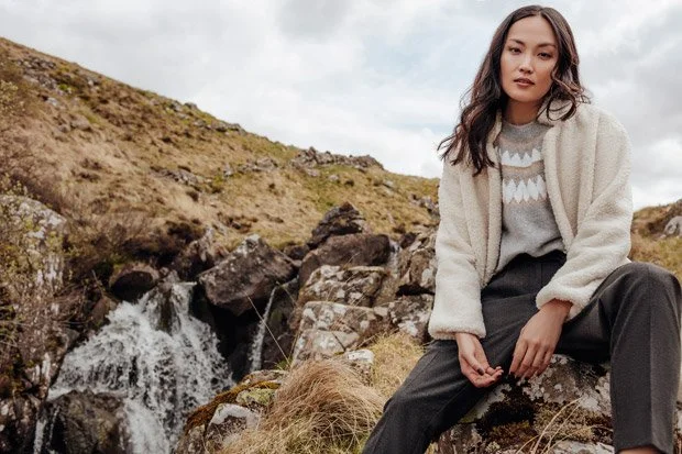 Promod 2018 collection - model wears warm Borg jacket, argyle knit jumper and trousers