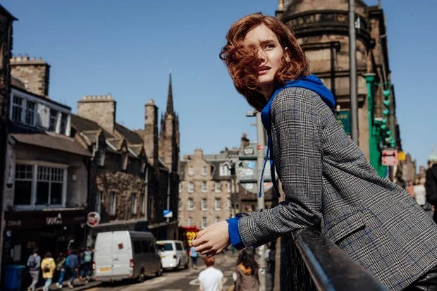 Promod 2018 collection - - model on Victoria street edinburgh wearing a bright blue hoodie which contratsts with her long red hair.