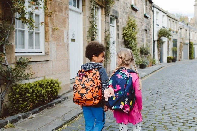Young Boy and girl show off their bright and bold rucksacks from Tea collection