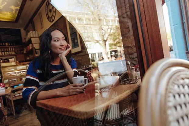 Model sits in an Edinburgyh cafe drinking coffee and looking out if the window