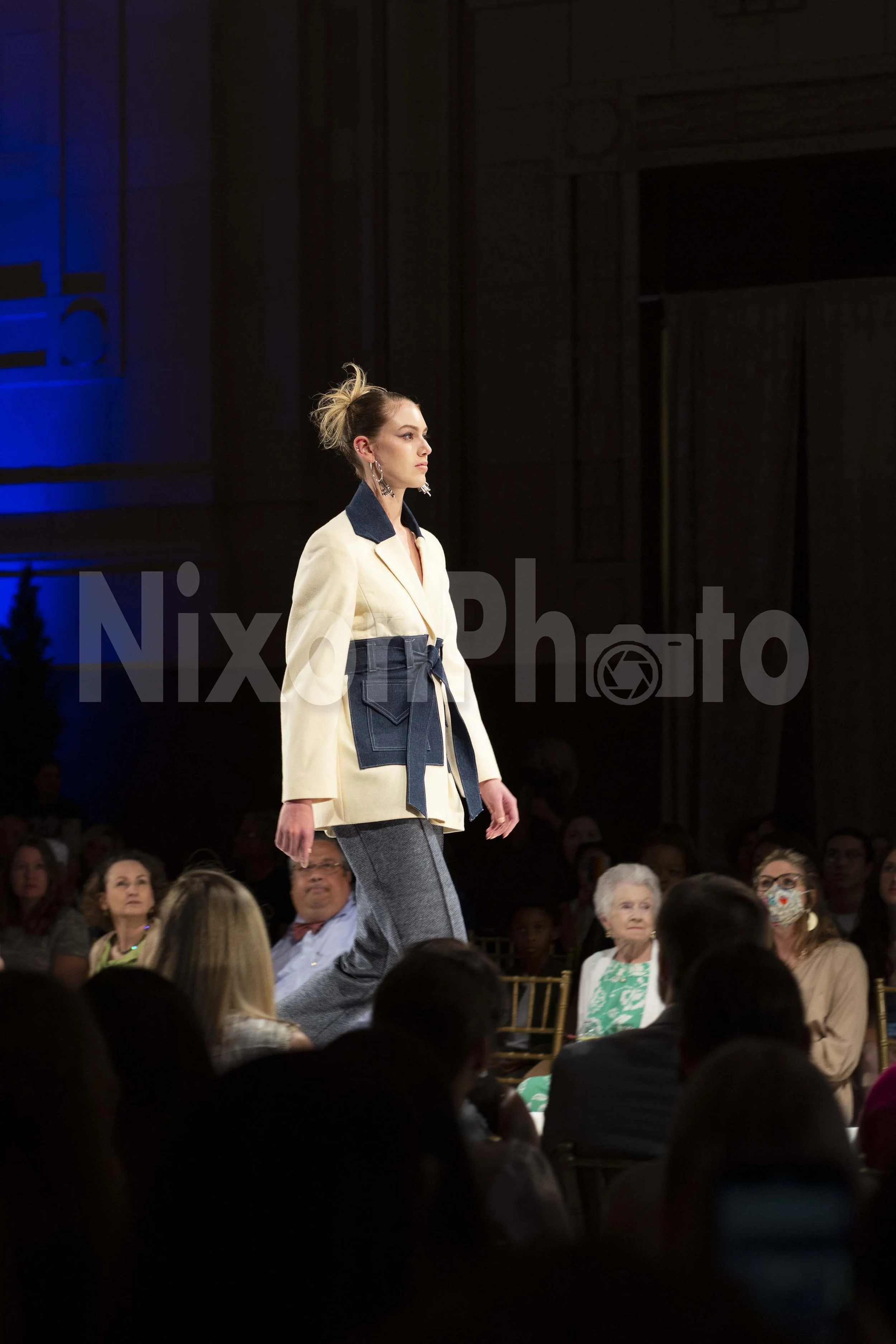Model walking on a fashion runway during a show.