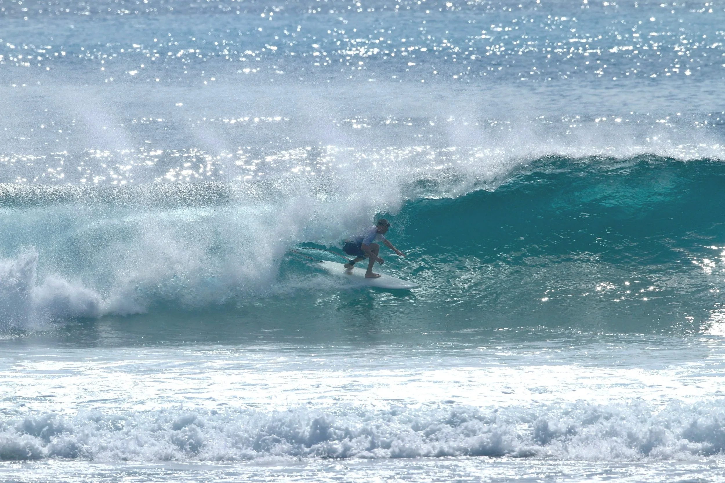 Michelle Kuroda, LAc, master acupuncturist in San Francisco, CA and Kailua-Kona, HI, specializing in nervous system regulation, neuromuscular re-education, embodied healing, and energy alignment - client surfing on wave in Hawaii.