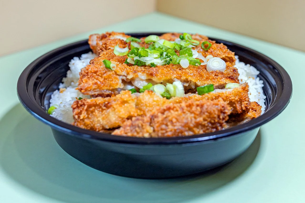 A bowl of panko breaded chicken with katsu sauce, served with two scoops of rice.