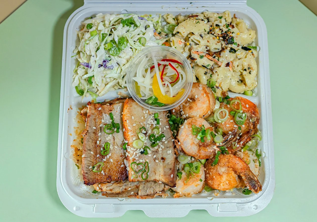 Garlic Butter Shrimp plus pork belly combination plate over rice with side of house slaw and macaroni salad.