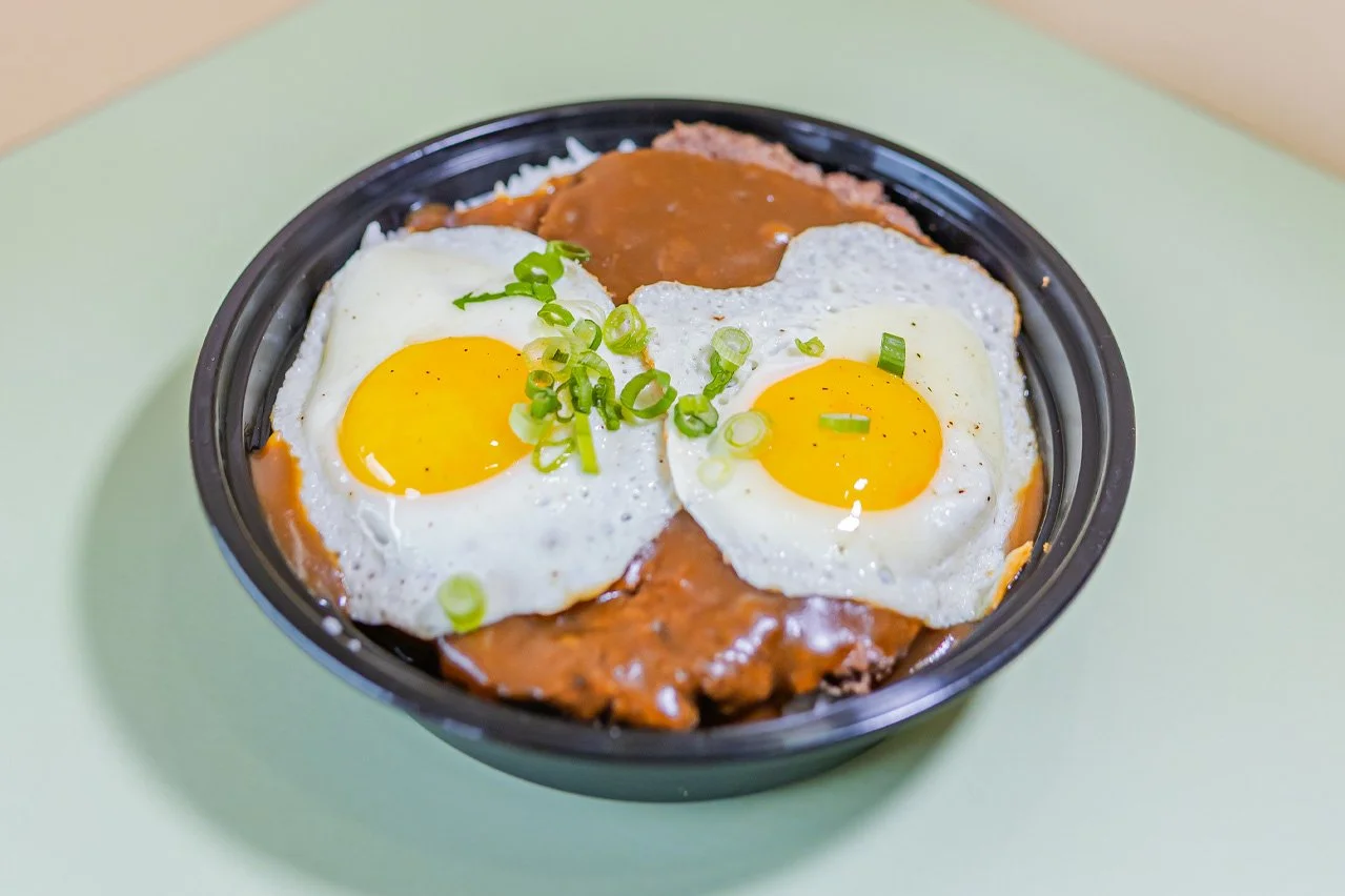 Two beef patties, brown gravy, sunny-side up egg, served with white rice.
