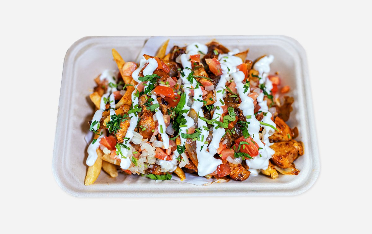 Savory & indulgent dish featuring crispy, rendered pork belly pieces, served over seasoned french fries and topped with sour cream, cilantro, white and green onion.