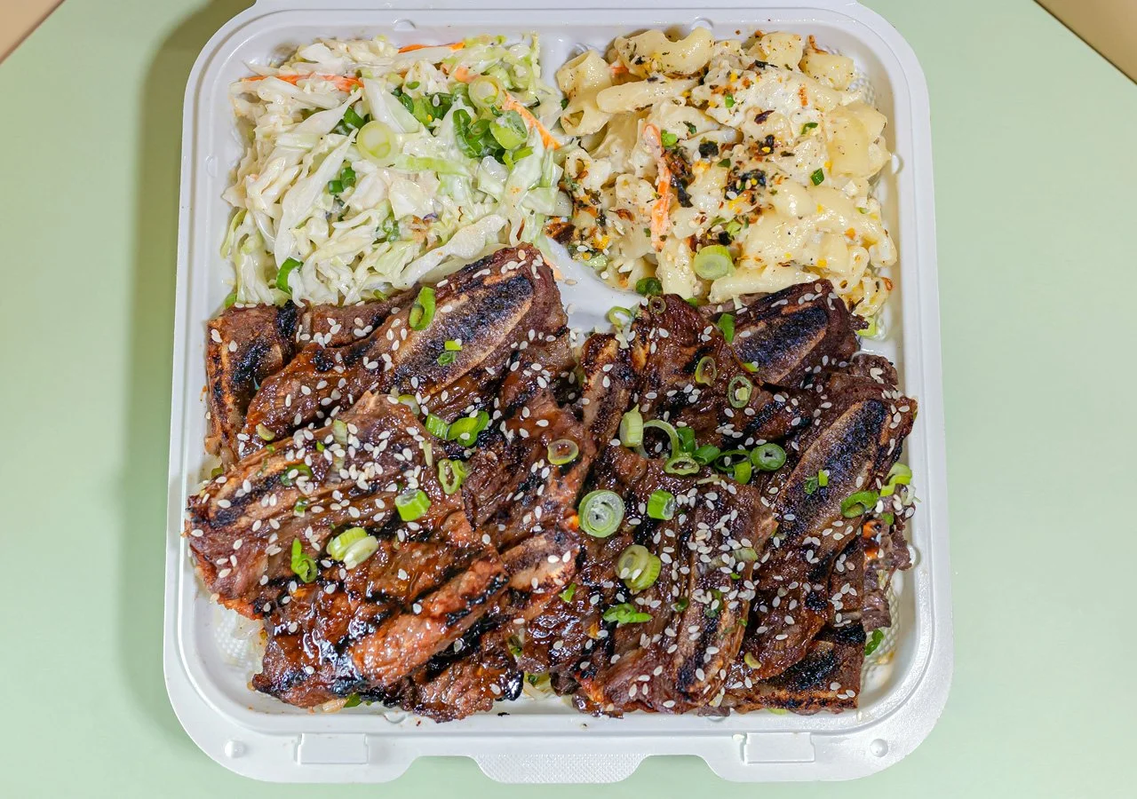 Single item plate of beef short ribs cut "flanken-style"—thinly across the bones—and marinated in a sweet, savory sauce of soy sauce, sugar, sesame oil, garlic over white rice.