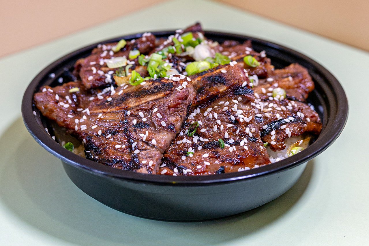 A bowl of beef short ribs cut "flanken-style"—thinly across the bones—and marinated in a sweet, savory sauce of soy sauce, sugar, sesame oil, garlic over white rice.