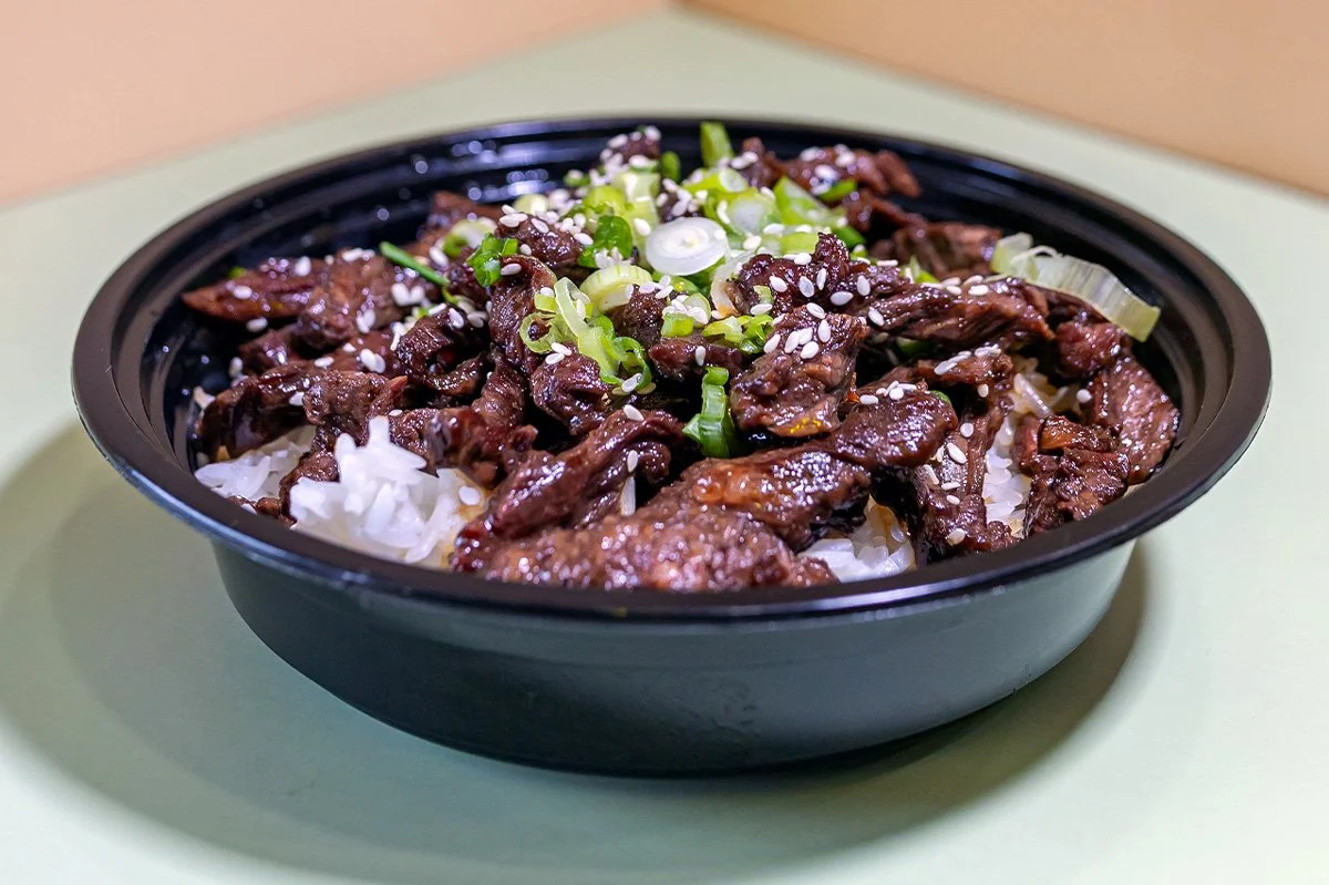 A bowl of Beef Skirt Steak Glazed with teriyaki sauce served over white rice.