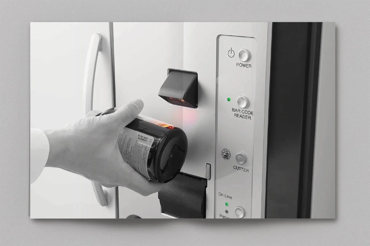 Kevin Schluter Design | Automation by Douglas | Service Design | A person wearing gloves is scanning a medication bottle on a medication safety device or station using a barcode scanner.