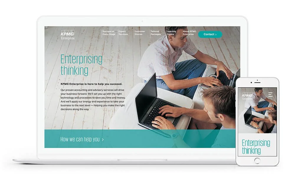 Laptop and smartphone displaying a website for KPMG Enterprise with an image of two people working on laptops and the text "Enterprising thinking."